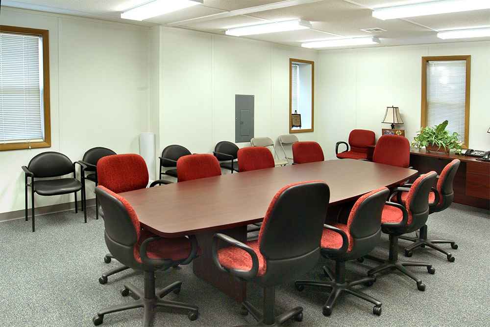 Modular office interior showing a conference room setup with red chairs and meeting table in USA