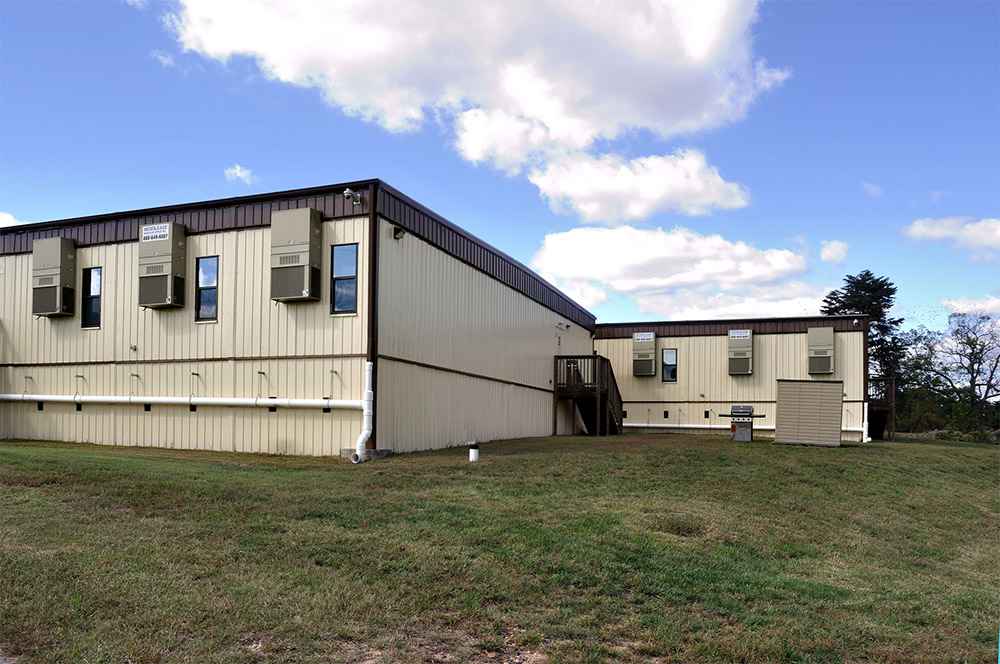 large modular classroom or office building with stairs and HVAC units on grassy land in USA